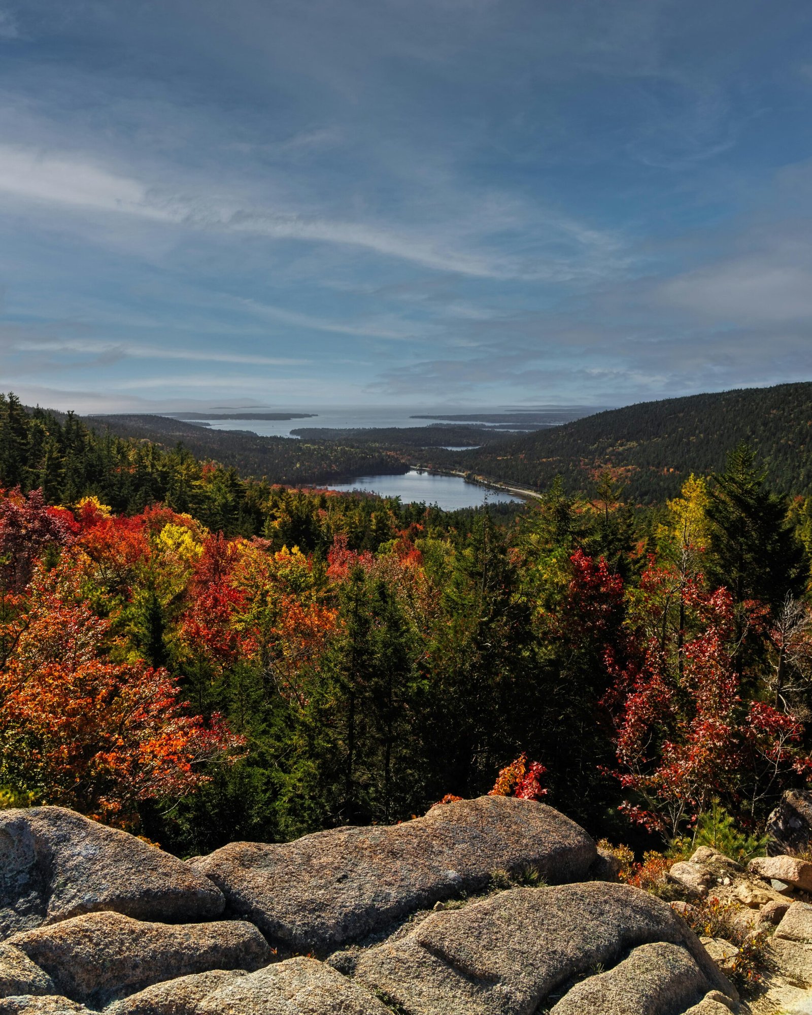 A breathtaking autumn landscape with colorful trees, a serene lake, and distant mountains.